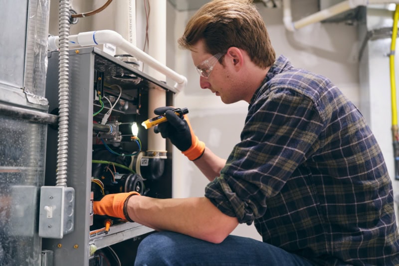 Technician performing furnace service in an Aurora home